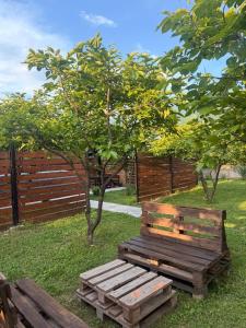 a wooden bench sitting in the grass next to a fence at NorWay1 in Ijevan +2 photos
