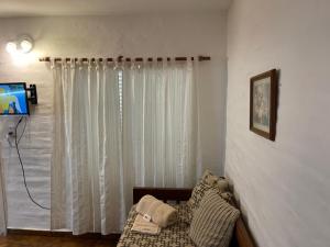 a living room with white curtains and a couch at Apart Hotel RioSol in Concepción del Uruguay