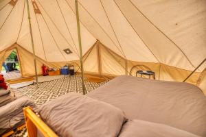 a tent with a bed in the middle of it at Naturally Glamping in Kingsteignton