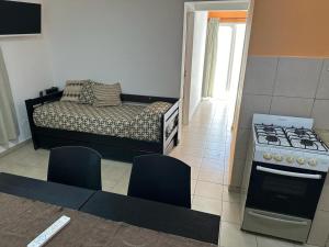 a kitchen with a stove and a bed in a room at Apart Hotel RioSol in Concepción del Uruguay