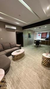 a living room with a couch and tables and a piano at قلب الشمال للشقق الفندقيه in Hail