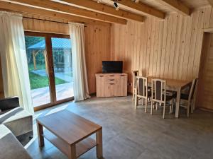 a living room with a table and a television at Domek Góra Gbura in Ulucz