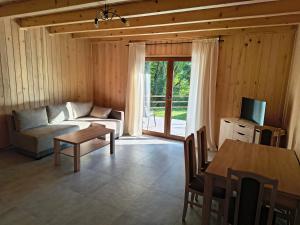 a living room with a couch and a table at Domek Góra Gbura in Ulucz +11 photos