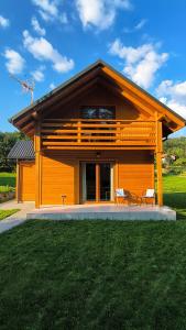 a house with a deck on top of a yard at Domek Góra Gbura in Ulucz