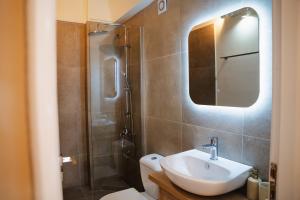 a bathroom with a sink and a shower with a mirror at Zoe Apartment Port View Β in Rafina +7 photos