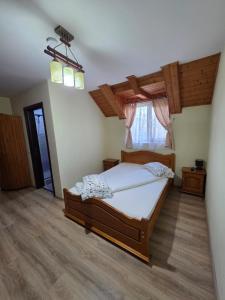 a bedroom with a large bed and a window at Pensiunea Casa Maria in Corbeni