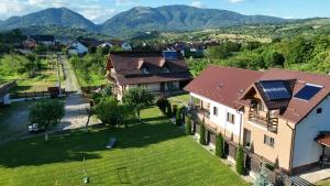 an aerial view of a house with mountains in the background at Pensiunea Casa Maria in Corbeni