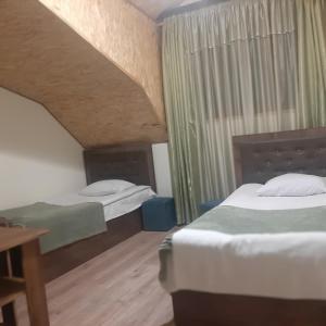 a room with two beds and a wooden table at Noy in Goris