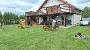 a house with a picnic table and a playground at Dom letniskowy Sieraków in Sieraków