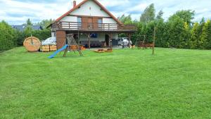 a house with a playground in a yard at Dom letniskowy Sieraków in Sieraków