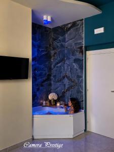 a woman sitting in a tub in a room at Dharma Luxury Room in La Spezia +20 photos
