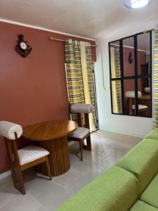 a living room with a table and chairs and a couch at Angevita City2 in Edéa +3 photos