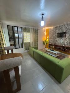 a living room with a green couch and a table at Angevita City2 in Edéa