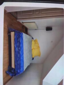 a room with a bed with blue and yellow sheets at Maison rollet in Aix-les-Bains