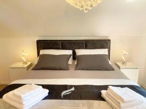 a bedroom with a large bed with towels on it at Empyrean House in Dišnik