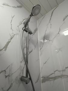 a shower in a bathroom with white marble at Myrtle House Hotel in Tenby +57 photos