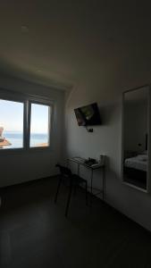 a room with a desk and a bed and a window at Torre Antica in Ioppolo