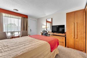 a hotel room with a bed and a flat screen tv at Motel Adam in Gatineau