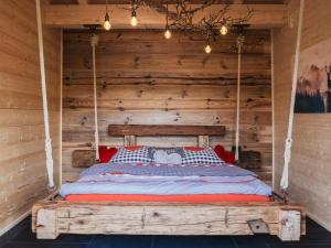 a bed in a room with a wooden wall at Romantikchalet Bärenhöhle mit eigenen Wellnessbereich, Komfort und viel Ruhe in Vorra