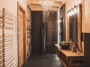 a bathroom with a sink and a chandelier at Romantikchalet Bärenhöhle mit eigenen Wellnessbereich, Komfort und viel Ruhe in Vorra +22 photos