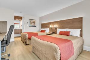 a hotel room with two beds and a flat screen tv at Motel Adam in Gatineau +53 photos