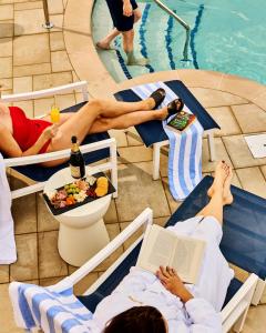 a group of people laying on chairs next to a swimming pool at Mirbeau Inn & Spa Beacon in Beacon