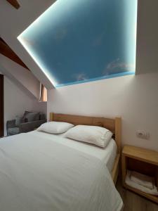 a bedroom with a bed with a blue ceiling at Gegest Hotel in Theth