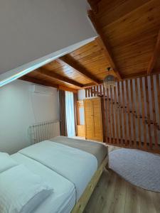a bedroom with a bed and a wooden ceiling at Gegest Hotel in Theth