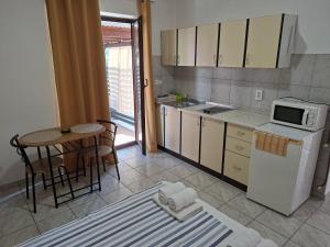 a small kitchen with a table and a microwave at Apartments I-P in Malinska