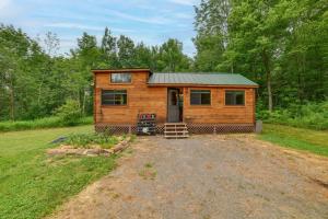 a log cabin in the middle of a field at Catskills Tiny Home Cabin: Surrounded by Nature! in Franklin