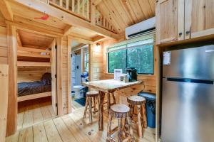 a kitchen with a table and stools in a tiny house at Catskills Tiny Home Cabin: Surrounded by Nature! in Franklin +23 photos