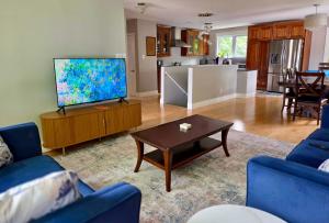 a living room with a flat screen tv and a table at Calm on the Crescent in St. John's