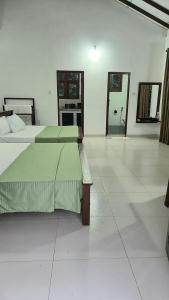 a large room with two beds and a kitchen at Emerald Mirror in Anuradhapura
