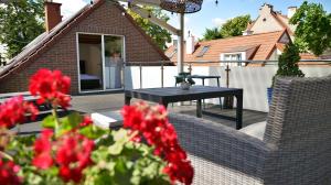 a patio with a black table and red flowers at Nadmorska Miła in Gdańsk