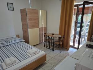 a bedroom with a bed and a table with a chair at Apartments I-P in Malinska