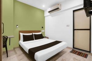 a bedroom with a white bed with black and green walls at Super Collection O MIDC Mahape Mumbai Formerly Hotel Didar House in Mumbai