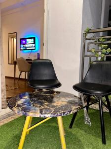 two black chairs and a table in a room at Skybloom stays in Greater Noida +4 photos