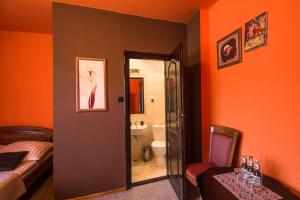 a bedroom with orange walls and a bed and a bathroom at Pensjonat Szczebel in Mszana Dolna +105 photos