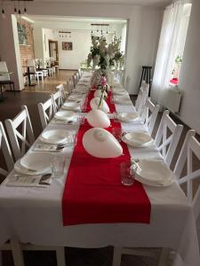 a long table with white plates and red napkins at Villa Podkarpacka in Kudowa-Zdrój