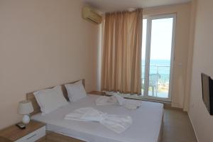 a bedroom with a bed with a view of the ocean at goldenseaview apartment 2 in Pomorie