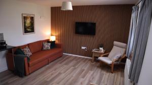 ein Wohnzimmer mit Sofa und Sessel in der Unterkunft Castle Rag in Lydney
