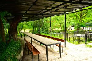 a picnic table and two benches under a pavilion at Loft Dilijan in Dilijan