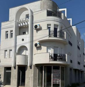 a white building with two balconies on the side of it at Angel Luxury Apartment in Kikinda