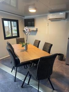 a dining room table with chairs and a vase of flowers on it at Jardin de Meliss in La Plaine des Cafres