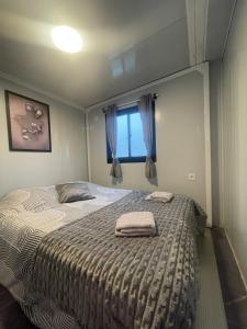 a bedroom with a bed with two towels on it at Jardin de Meliss in La Plaine des Cafres