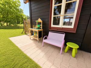 a chair and a stool next to a house at La maison IDEL in Yvonand