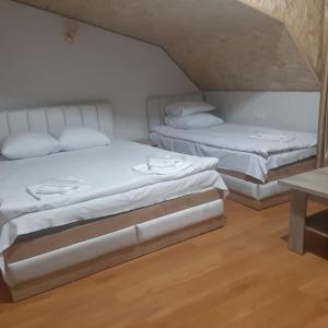 two beds in a room with white sheets and pillows at Noy in Goris