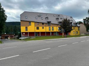a large yellow house on the side of a road at Apartmán Deštná čp.1 in Deštné v Orlických horách