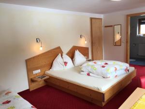a bedroom with a bed with white sheets and pillows at Alpenecho in Neustift im Stubaital