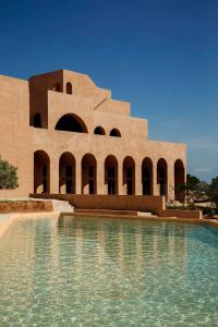 a building with a pool of water in front of it at Nômade Temple Ibiza - New Opening in Portinatx